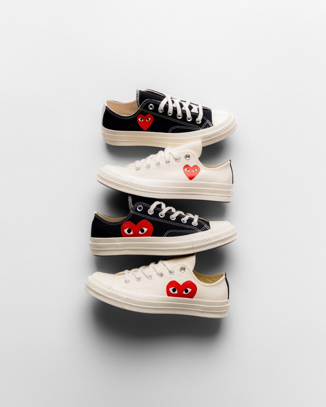 Four Comme des Garçons PLAY × Converse canvas sneakers with red heart patch
